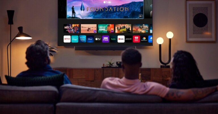 An excited fan watching a live football game on multiple screens—a large living room TV, a tablet, and a smartphone—showcasing the flexibility of IPTV streaming